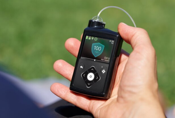 Small medical device resting on a person's palm